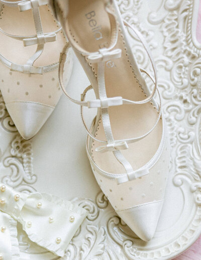 A white background with pair of elegant Bella Shoes delicately on top during the getting ready photos on the Big Day.