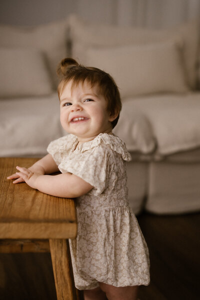 Photographer educator aimee kelly takes a photograph of a mother and son while they sit in her studio on the sofa