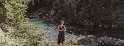 woman in black jumpsuit standing by BC lake