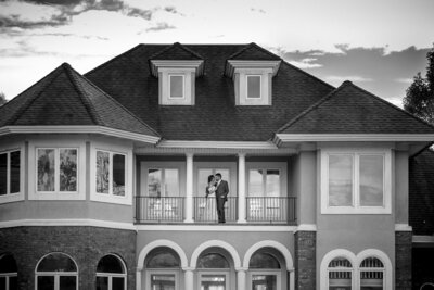 Black-and-white-image-of-couple-kissing-on-the-balcony-of-the-home-at-the-Pointe-at-Lake-Hickory