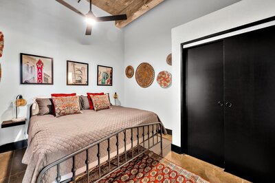 Bedroom with comfortable bedding in this two-bedroom, two-bathroom vacation rental condo in the historic Behrens building in downtown Waco, TX just blocks from the Silos, Baylor University, and Spice Street.