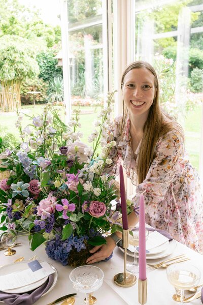 Weddingplanner die bloemstuk op tafel legt, wedding styling
