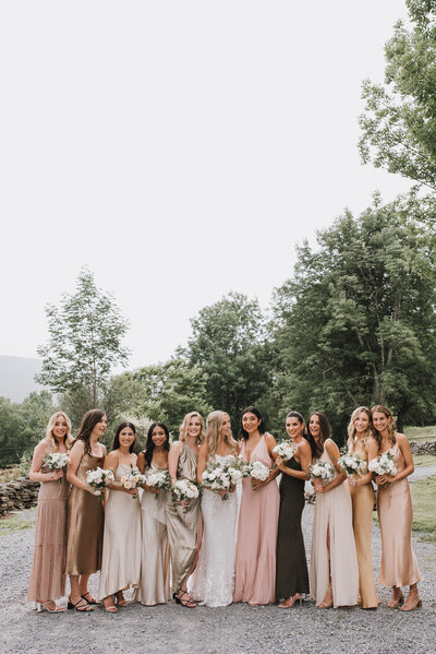 A Catskills bride and her wedding party in mismatched neutral satin bridesmaids' gowns.