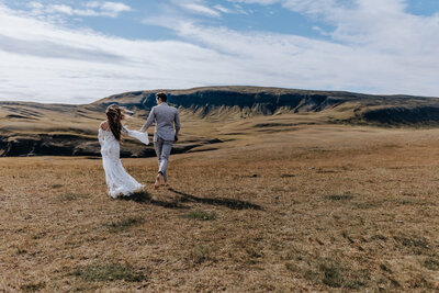Iceland elopement photographer captures outdoor elopement of couple walking through field