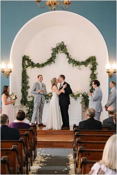 a port gamble wedding ceremony where the couple is kissing