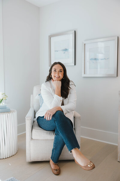 Sarah Wagner Wilmington Realtor for Jacie and Co sitting in chair wearing a white blazer.