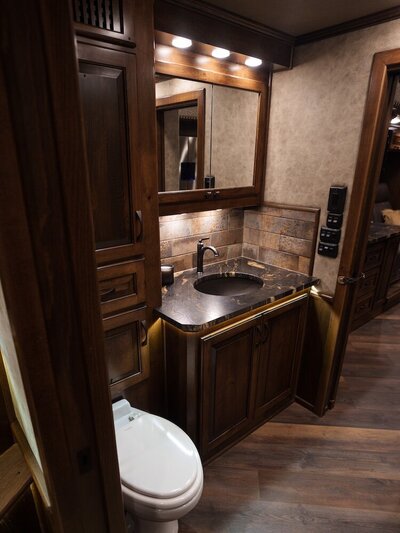 Luxury horse trailer bathroom with dark cabinets and sink