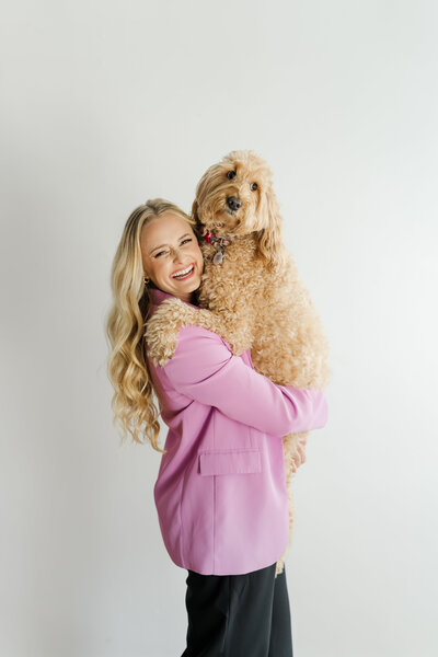 South Florida wedding photographer hugging her golden doodle dog