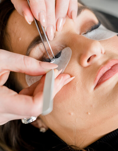 Client receiving eyelash enhancements from Ashley Turner