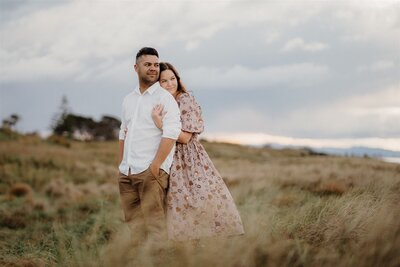 A couple hugging in the dunes at Papamoa Beach, photographed by Tashina Narelle Photography and Videography