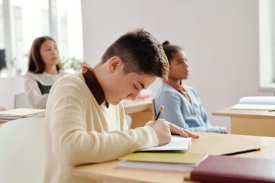 Student avoiding work with a book over her face