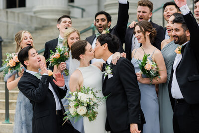 Bride and groom kissing with wedding guests cheering at the Minneapolis Institute of Art