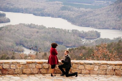 photo of man proposing to her girlfriend in front of the river