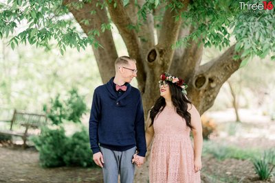 Engaged couple share a kiss during and engagement session at the Fullerton Arboretum