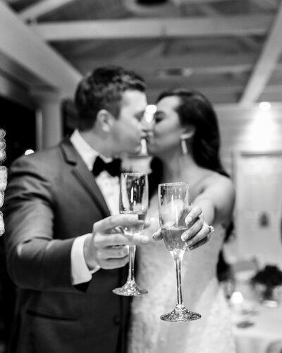 The bride and groom share a toast and a kiss at their reception at the Mackey House in Savannah, Georgia