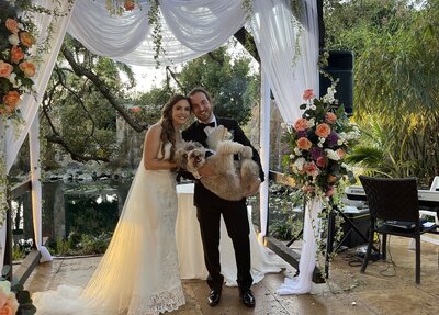 wedding couple holding wedding dog