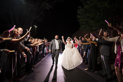Nighttime glow stick send-off at the Embassy Suites Hilton Charlotte by Charlotte wedding photographers DeLong Photography