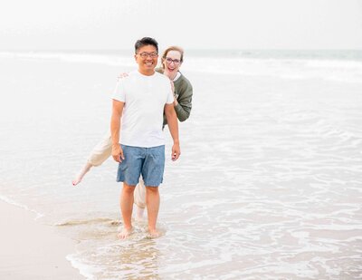 couple playfully posing on a beach in golden hour for a fayetteville nc photographer