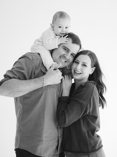Allison and husband holding ultrasound photos on the beach