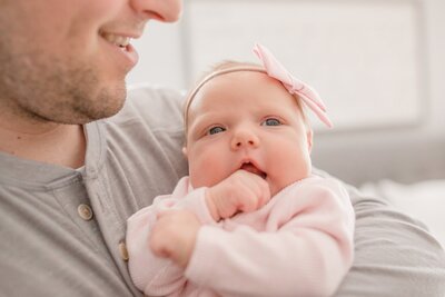 Father holds baby in newborn family photoshoot in Minnesota.