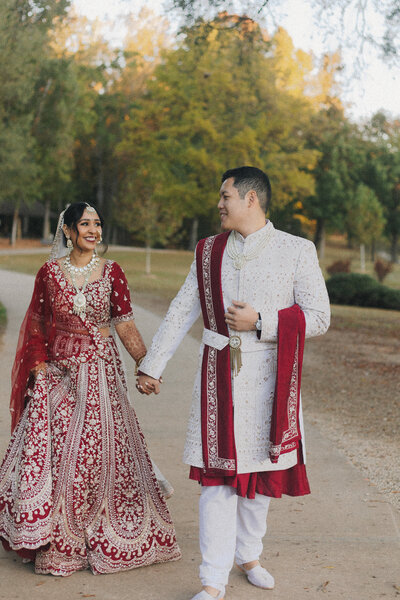 Couple holding hands wearing traditional Indian ceremonial outfits