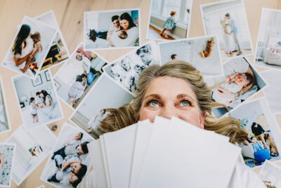 Natasha Sewell lying down on photo prints by her