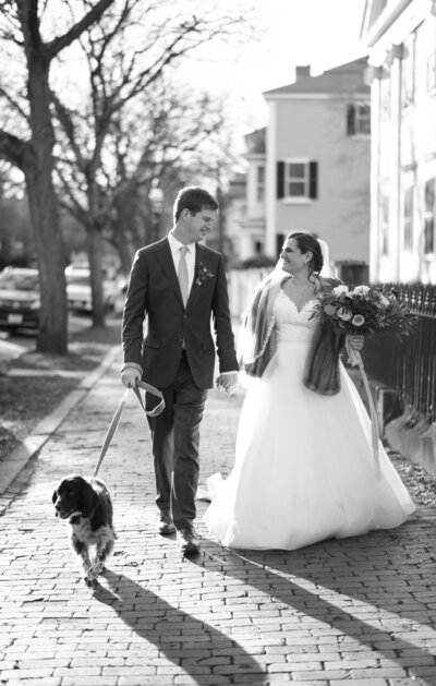 Bride and Groom walking together with dog on leash