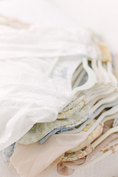 A close up photo of a pile of dresses on hangers
