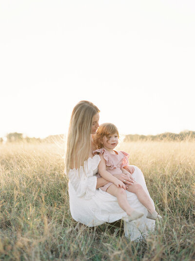 Mother and daughter sitting together in a field