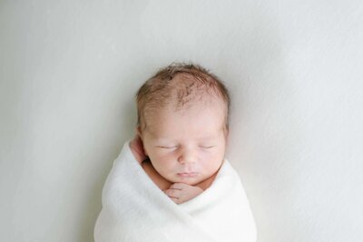 newbornshoot baby jongen ingebakerd in wit doek