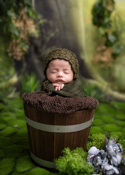newborn boy sleeping inside a bucket, forest theme