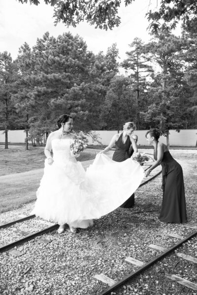 Bridesmaids carry the train of their bride's wedding gown