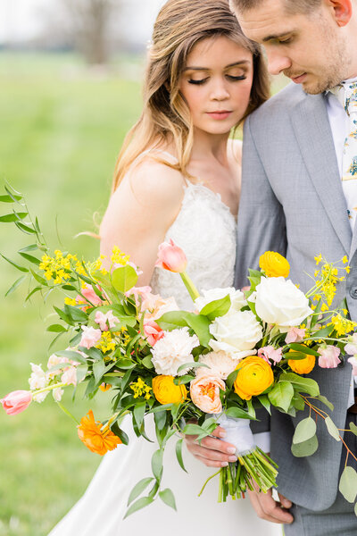 romantic bride and groom portraits with yellow pink and white bouquet at the granary wedding venue in virginia
