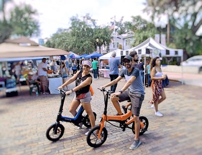 Married couple cruising around on there Blue Go-Bike M3 & Orange Go-Bike M4 at a local festival