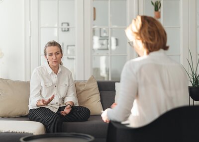 Woman sitting on a couch talking with a therapist