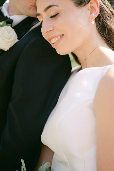 Portrait of a bride snuggled up to her groom on her wedding day