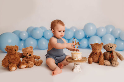 Baby enjoys birthday cake during his cake smash photoshoot in Asheville, NC.