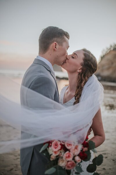 Lake Tahoe wedding photographer captures beach wedding with bride kissing groom
