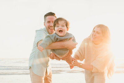 Family Photography, couple playing with their toddler at the beach