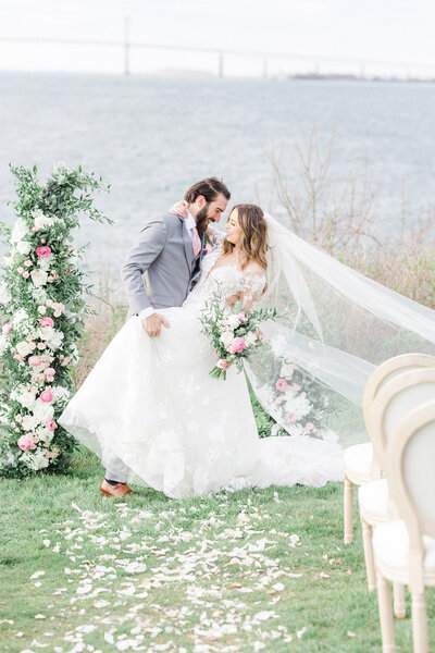 Bride and Groom in Coastal Wedding with soft pink florals.