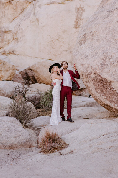 bride and groom embracing by rocks