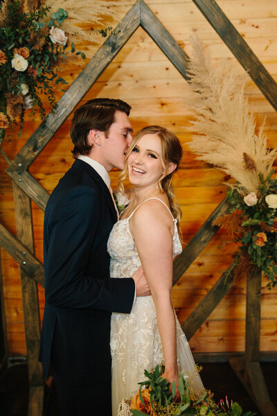 Jackson Hole photographers capture groom kissing bride on cheek