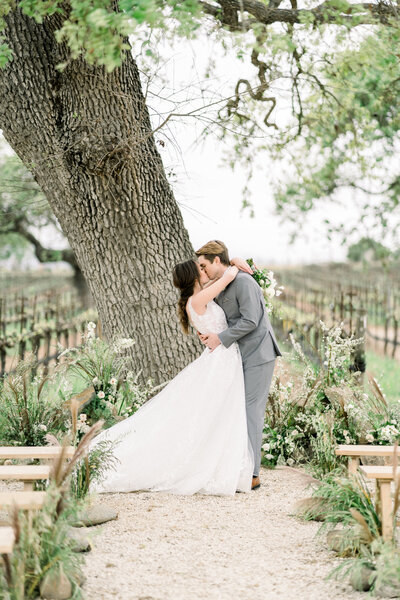 Bride and groom at ceremony alter under oak tree Sunstone Winery wedding in Santa Ynez, CA
