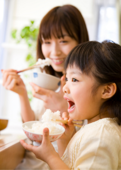 Thrive by Spectrum Pediatrics image for family mealtime coaching is a child happily eating with mother during mealtime