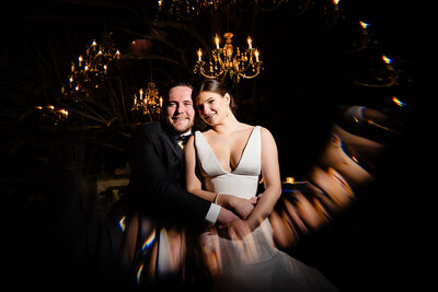 A wedding couple sitting close together with light shining around them