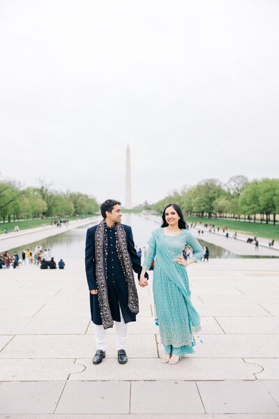 Bride and groom, wearing Indian garments at the national Mall in Washington DC with monuments.