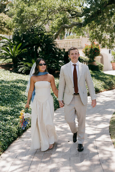 bride and groom walking together hand in hand on their elopement day on st. simons island, georgia 