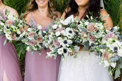 Bride and bridesmaid with pink, white, and green bouquets