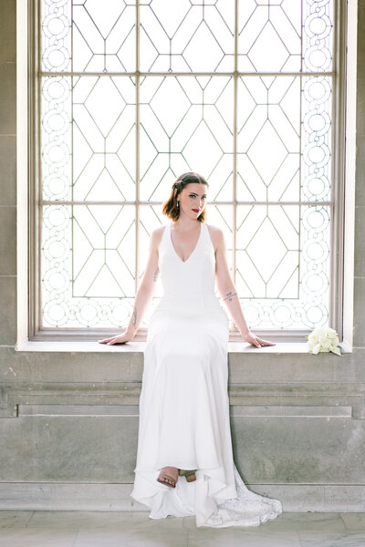 Bride sitting at the  San Francisco City Hall window during her Wedding