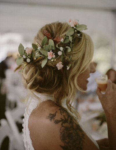 Boho bride with low side bun and flowers in hair